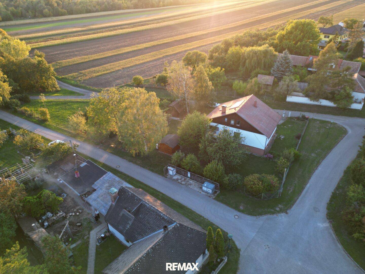 Panoramablick auf ein Wohnhaus mit Garten, umgeben von Feldern und weiteren Häusern in der Nachbarschaft.