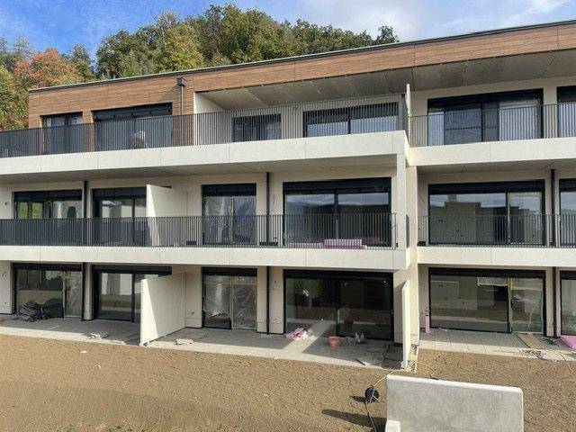 Nahaufnahme der modernen Fassade eines Neubaus mit großzügigen Balkonen und Terrassenbereichen.