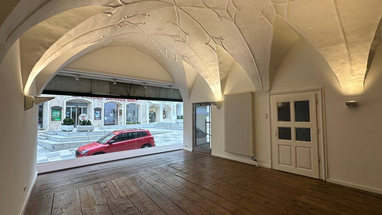Raum mit beeindruckendem Gewölbe und Holzdielenboden, Blick auf den Stadtplatz.