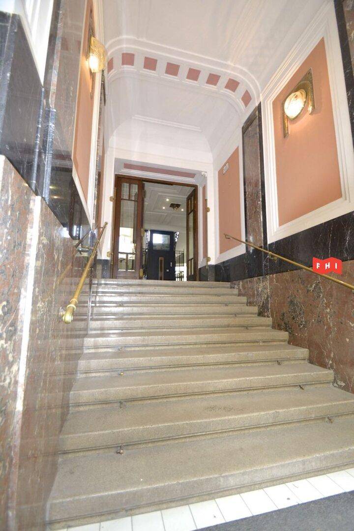 Repräsentatives Treppenhaus mit Marmorverkleidung und eleganten Handläufen.