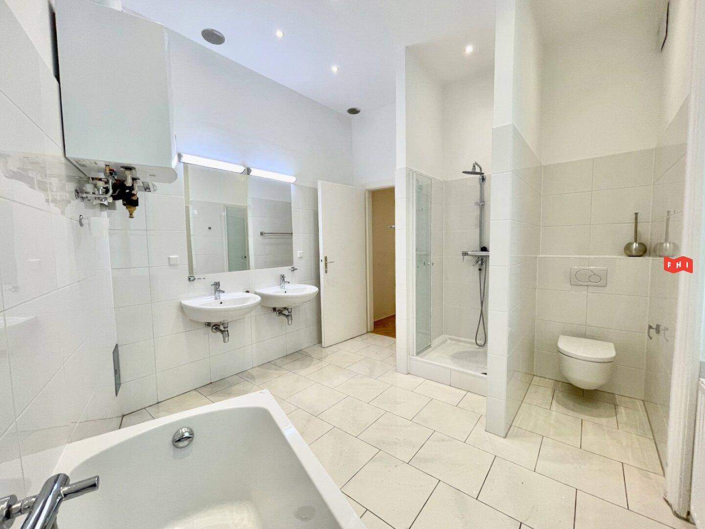 Geräumiges Badezimmer mit Badewanne, Dusche, WC und zwei Waschbecken.