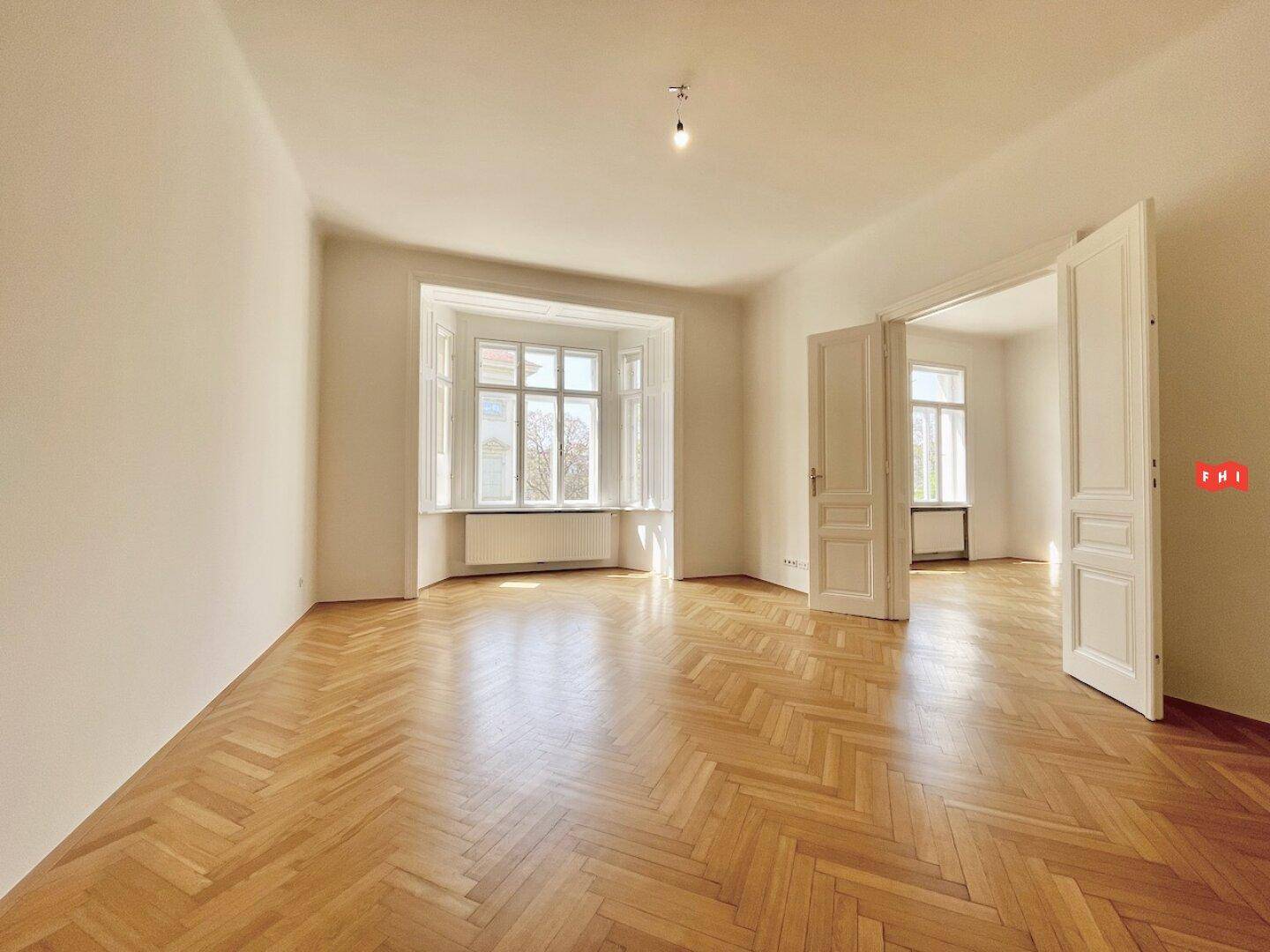 Helles Wohnzimmer mit Fischgrätparkett und Erkerfenster, bereit zur individuellen Gestaltung.