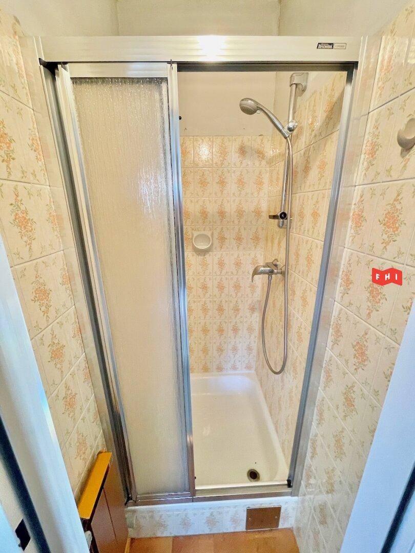 Badezimmer mit Duschkabine und gemusterten Fliesen im traditionellen Stil.