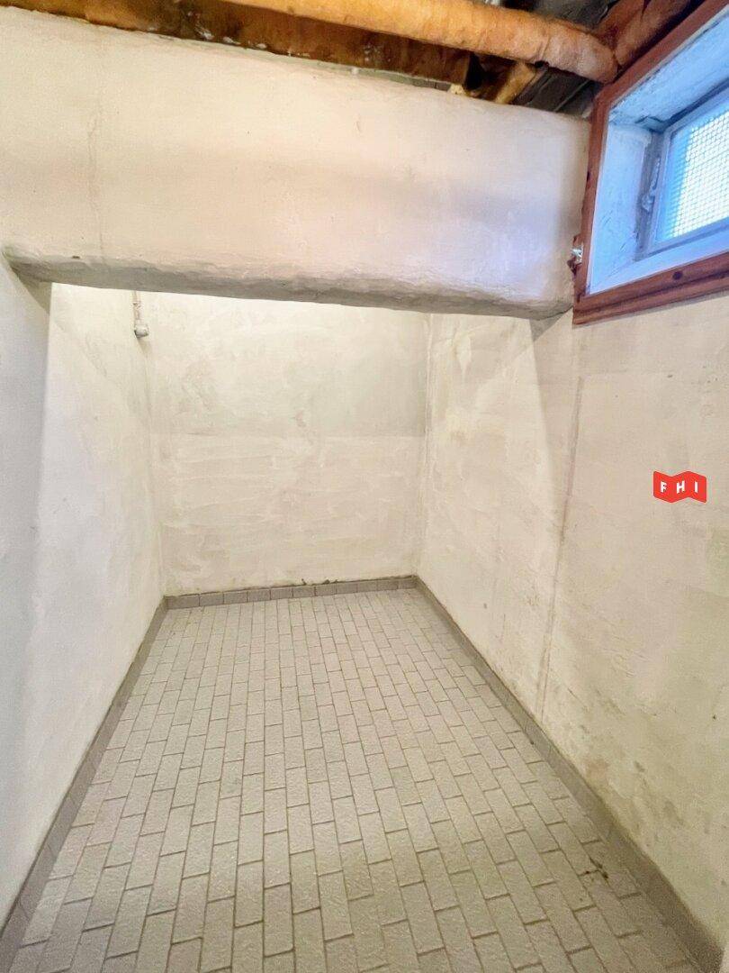 Kellerraum mit gefliestem Boden und einem kleinen Fenster für Belüftung.