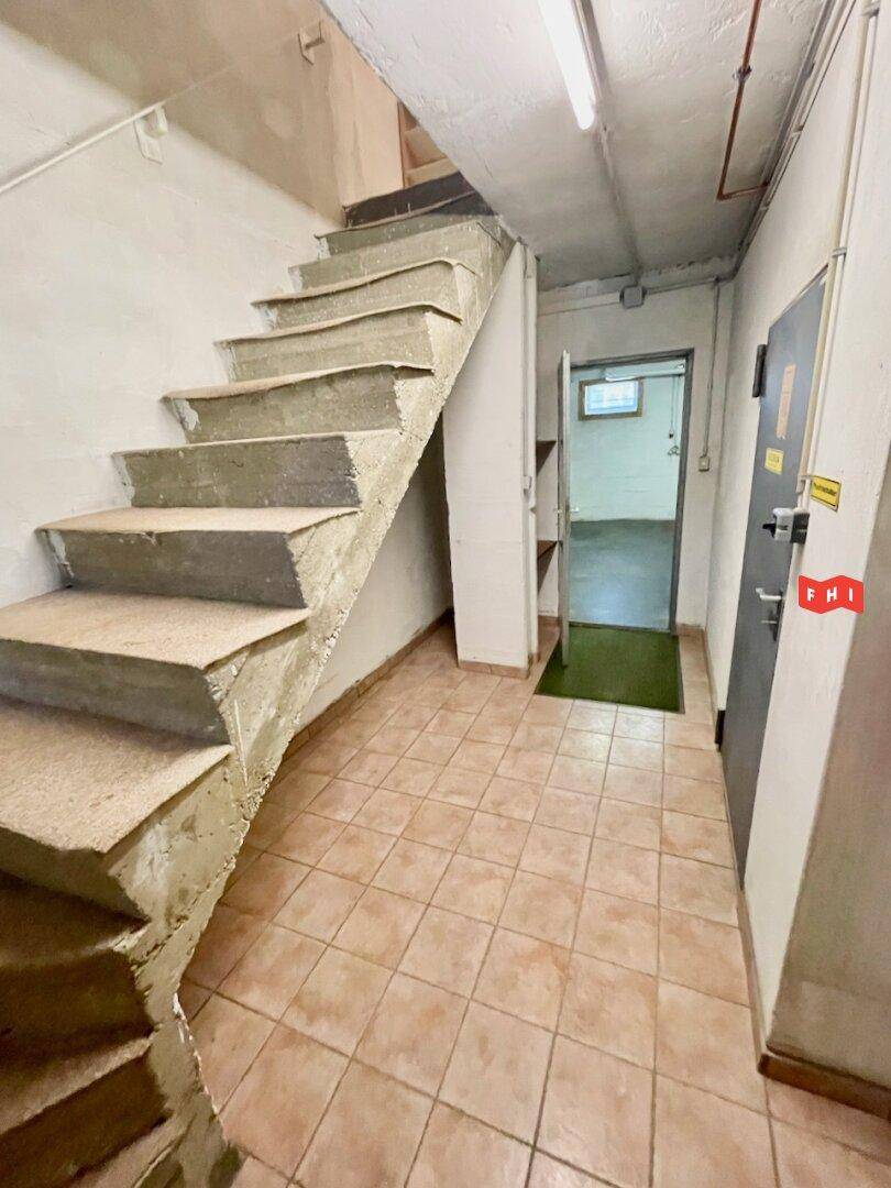 Kellerbereich mit Betontreppe und gefliestem Boden, der zu weiteren Räumen führt.