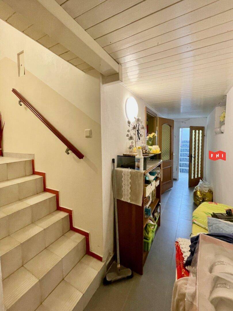Kellerflur mit Treppe, Holzdecke und Zugang zu weiteren Räumen im Untergeschoss.