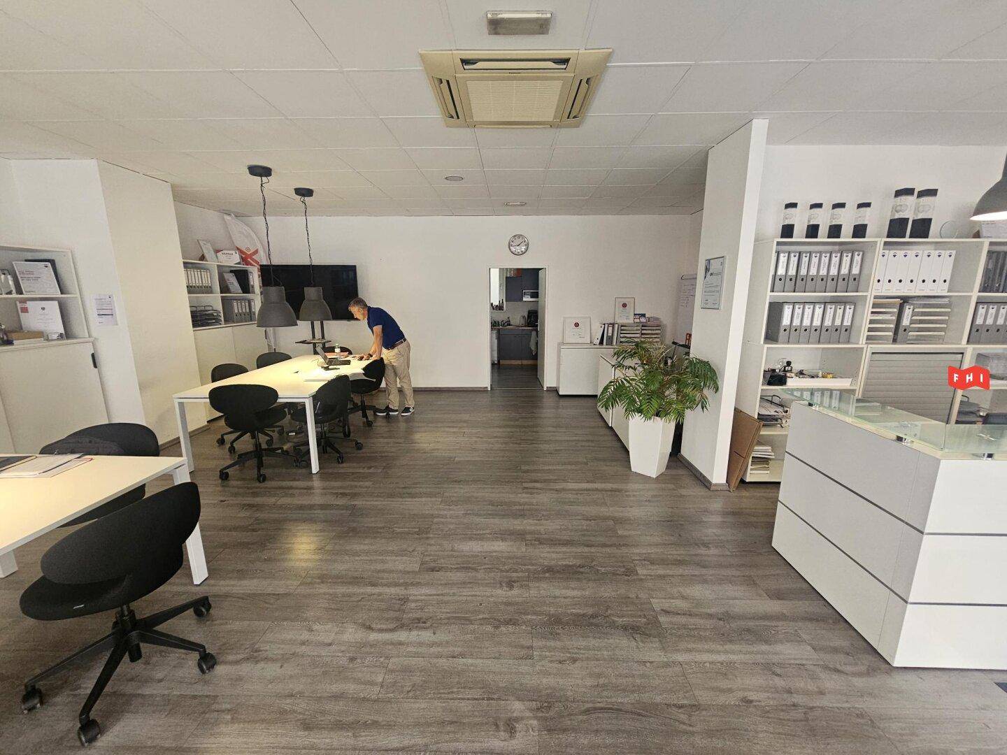 Großes, helles Büro mit Empfangstheke, Besprechungsbereich und Klimaanlage.
