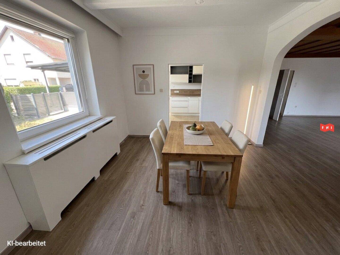 Heller Essbereich mit Holztisch, Stühlen und Laminatboden, verbunden mit der Küche.