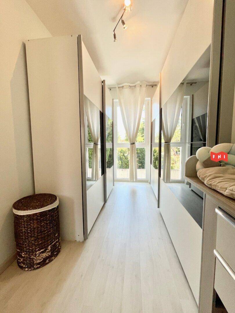 Schmaler Flur mit Spiegelschränken, der viel Licht durch die Fenster reflektiert.