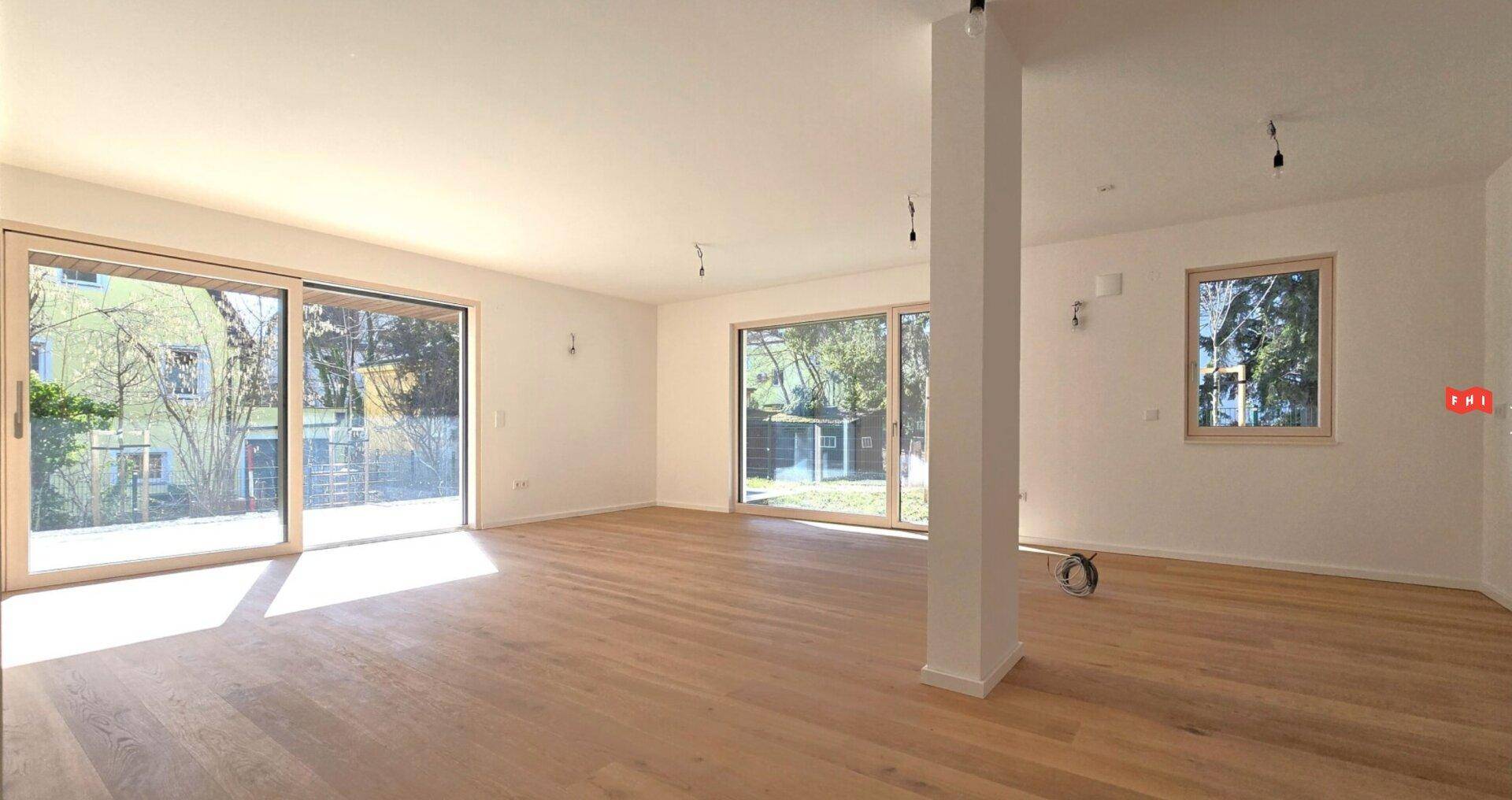 Geräumiges, helles Zimmer mit Holzboden und Säule, bereit zur Einrichtung.