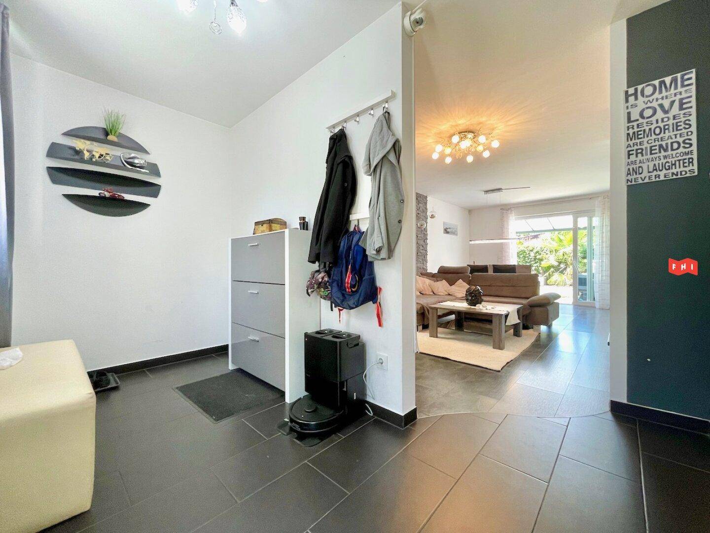 Eingangsbereich mit Garderobe, Schuhschrank und Blick in den offenen Wohnbereich.