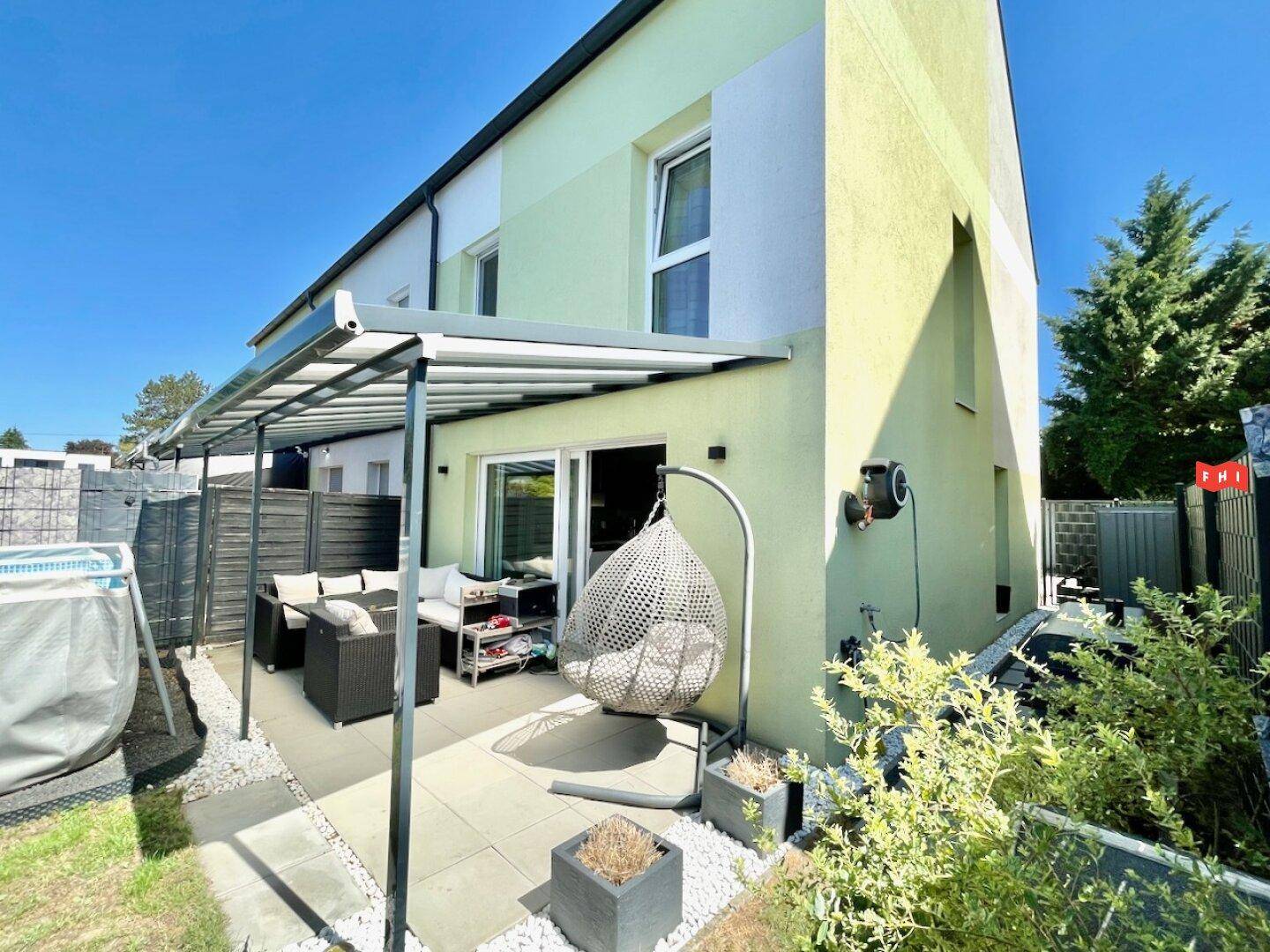 Überdachte Terrasse mit Loungemöbeln und direktem Zugang zum Garten.