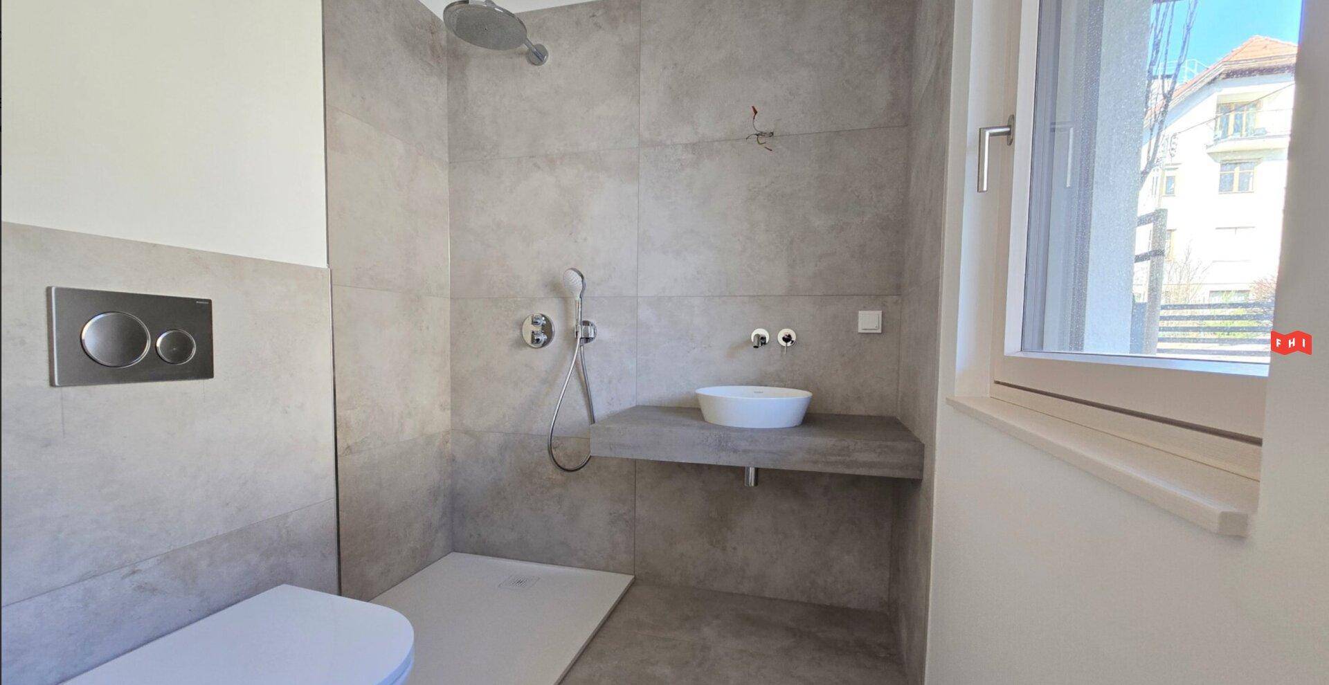 Modernes Badezimmer mit begehbarer Dusche, Wand-WC und Fenster.