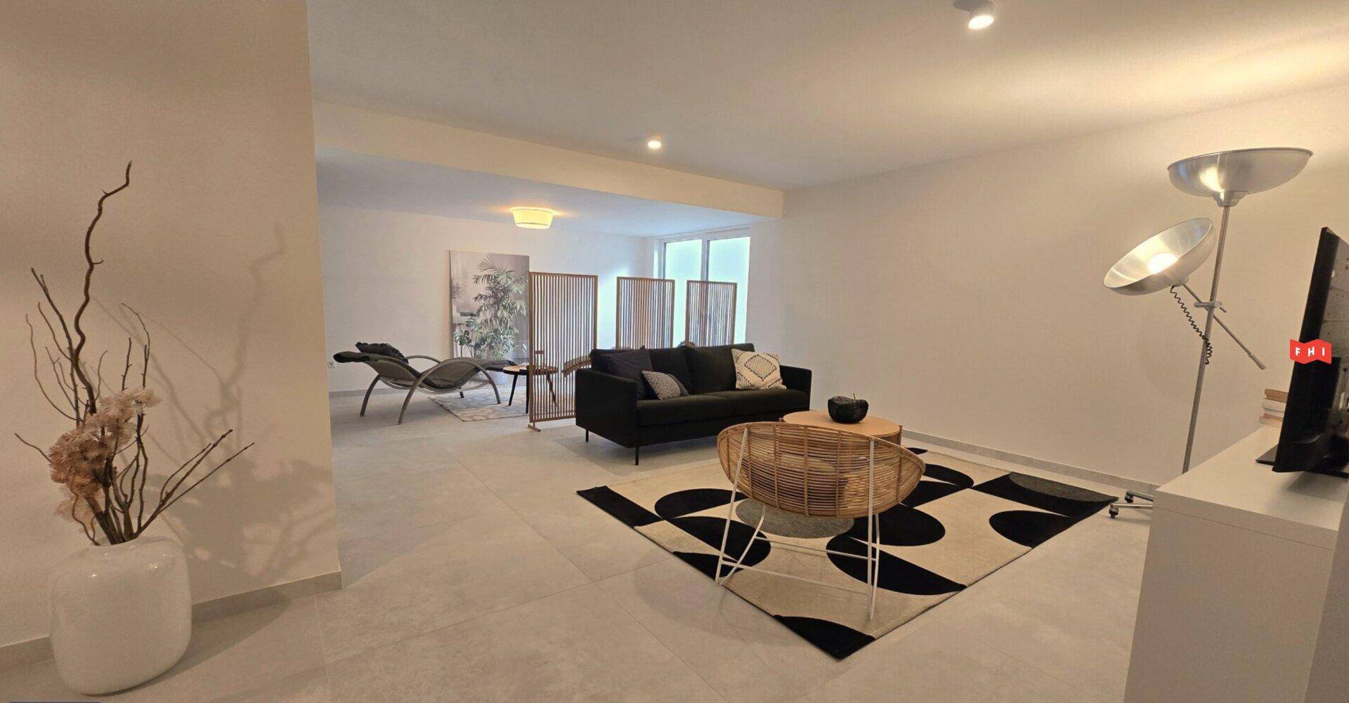 Modern eingerichtetes Wohnzimmer mit beigem Teppich und stilvollen Möbeln.