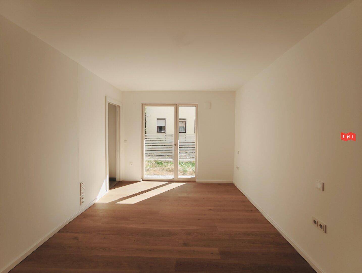 Helles Schlafzimmer mit dunklem Eichenparkett und großen Fenstern für viel Tageslicht.
