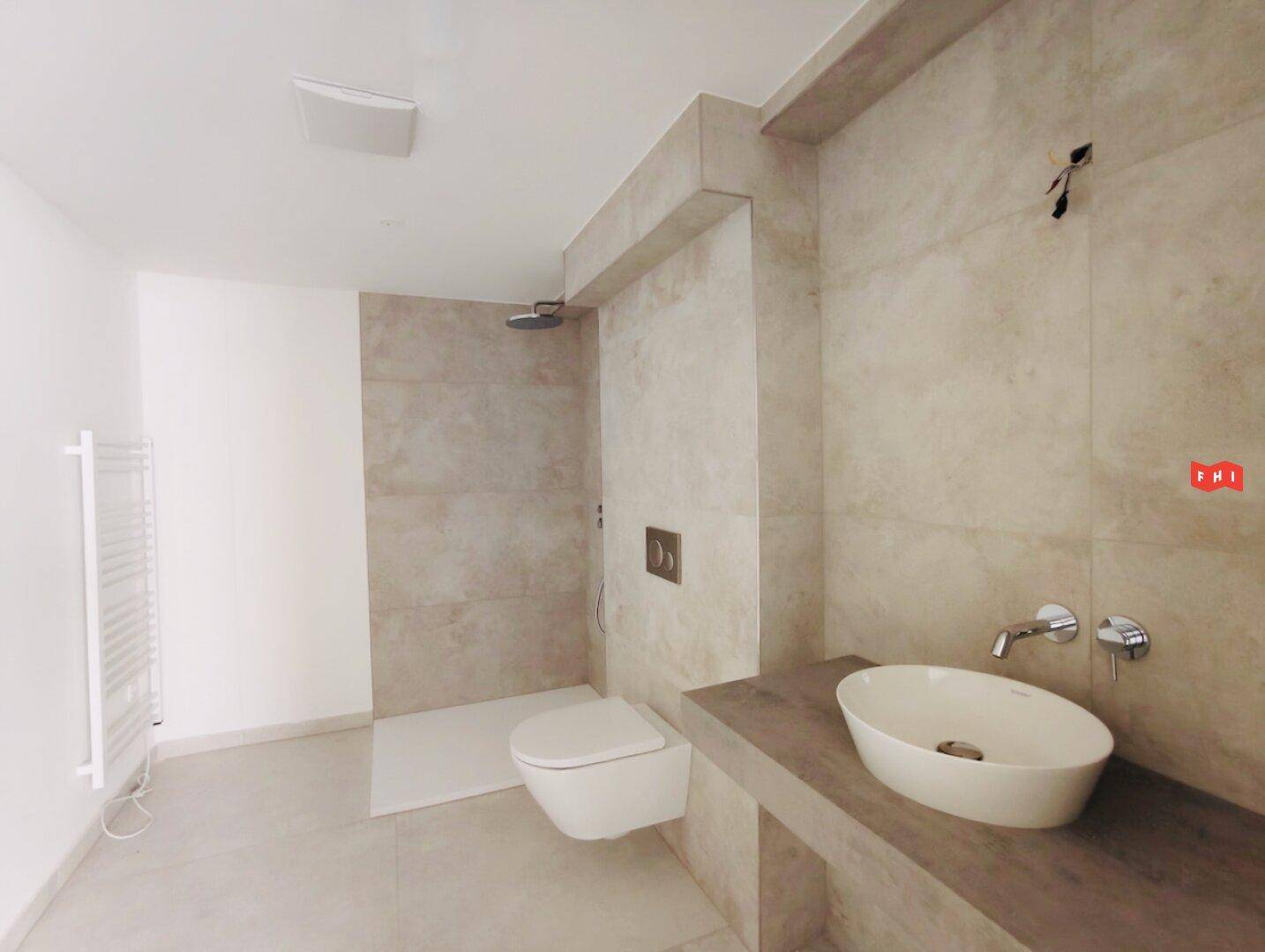 Modernes Badezimmer mit begehbarer Dusche, Wand-WC und stilvollem Waschbecken auf schwebendem Waschtisch.