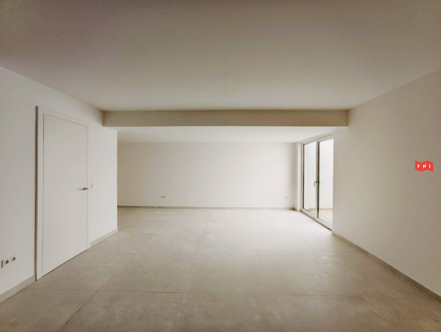 Heller, leerer Raum mit großen Schiebetüren und modernem Fliesenboden, bereit zur individuellen Gestaltung.
