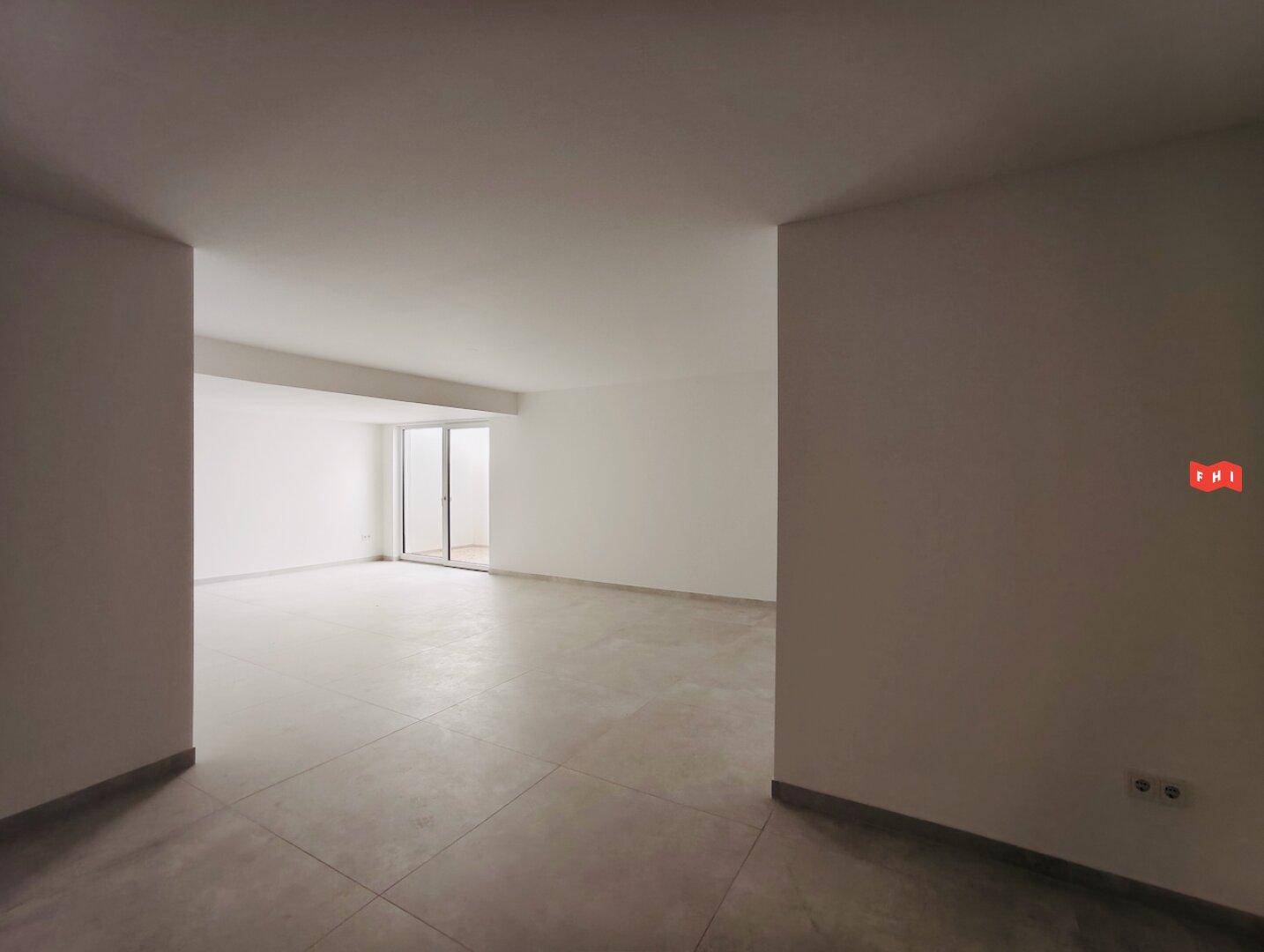 Geräumiger, heller Wohnbereich mit Fliesenboden, der auf eine offene Gestaltung hindeutet.
