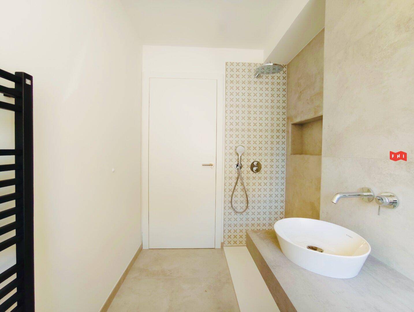 Modernes Badezimmer mit begehbarer Dusche, Einzelwaschbecken und beheiztem Handtuchhalter.