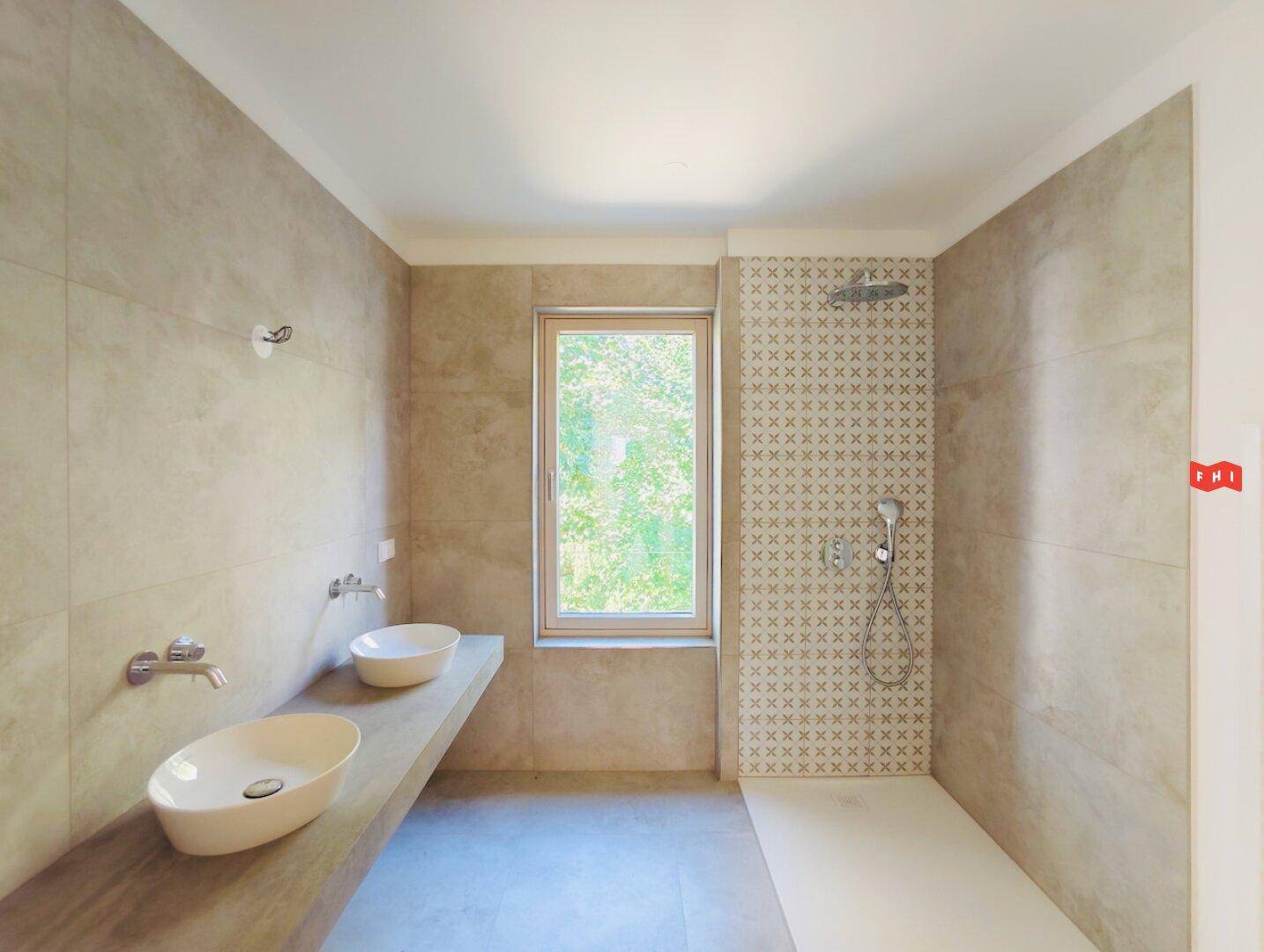 Modernes Badezimmer mit zwei Aufsatzwaschbecken, großer Dusche und Fenster.