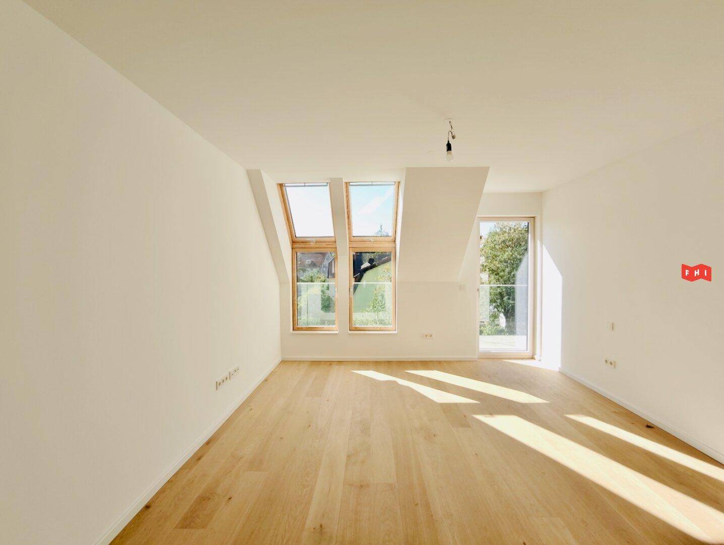 Geräumiges Wohnzimmer mit Holzboden, Dachfenstern und viel natürlichem Sonnenlicht.