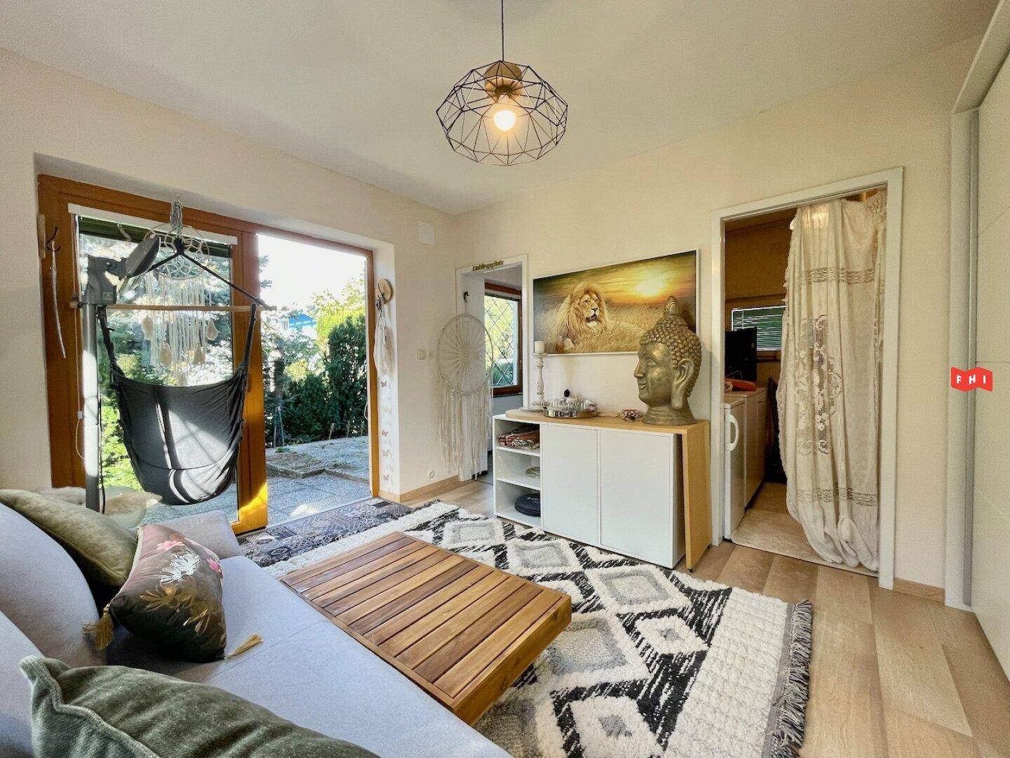 Wohnzimmer mit Zugang zur Terrasse, beigem Sofa und dekorativen Elementen, hell und einladend.