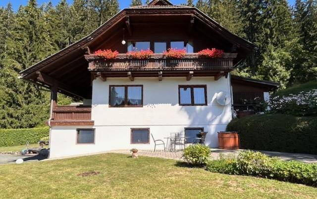 Charmantes Haus im alpinen Stil mit Balkon und gepflegtem Vorgarten.