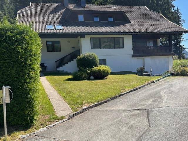 Ansicht des Hauses von der Auffahrt mit gepflegtem Rasen und Hecke.