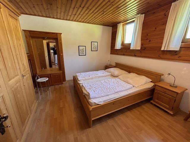 Schlafzimmer mit Holzwänden, Holzboden und traditionellen Möbeln.