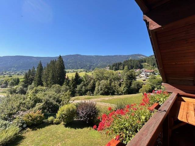 Malerischer Ausblick vom Balkon mit Blumenkästen auf die Berglandschaft.