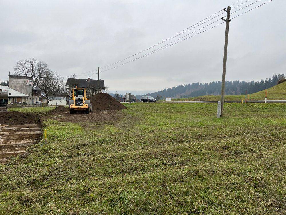 Ländliches Grundstück mit Erdhügeln und Baumaschinen, bereit für die Bebauung.