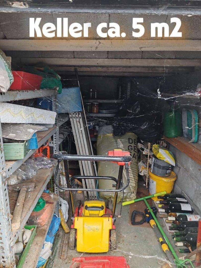 Unaufgeräumter Kellerraum von etwa 5 m² mit Regalen und verschiedenen Lagergegenständen.
