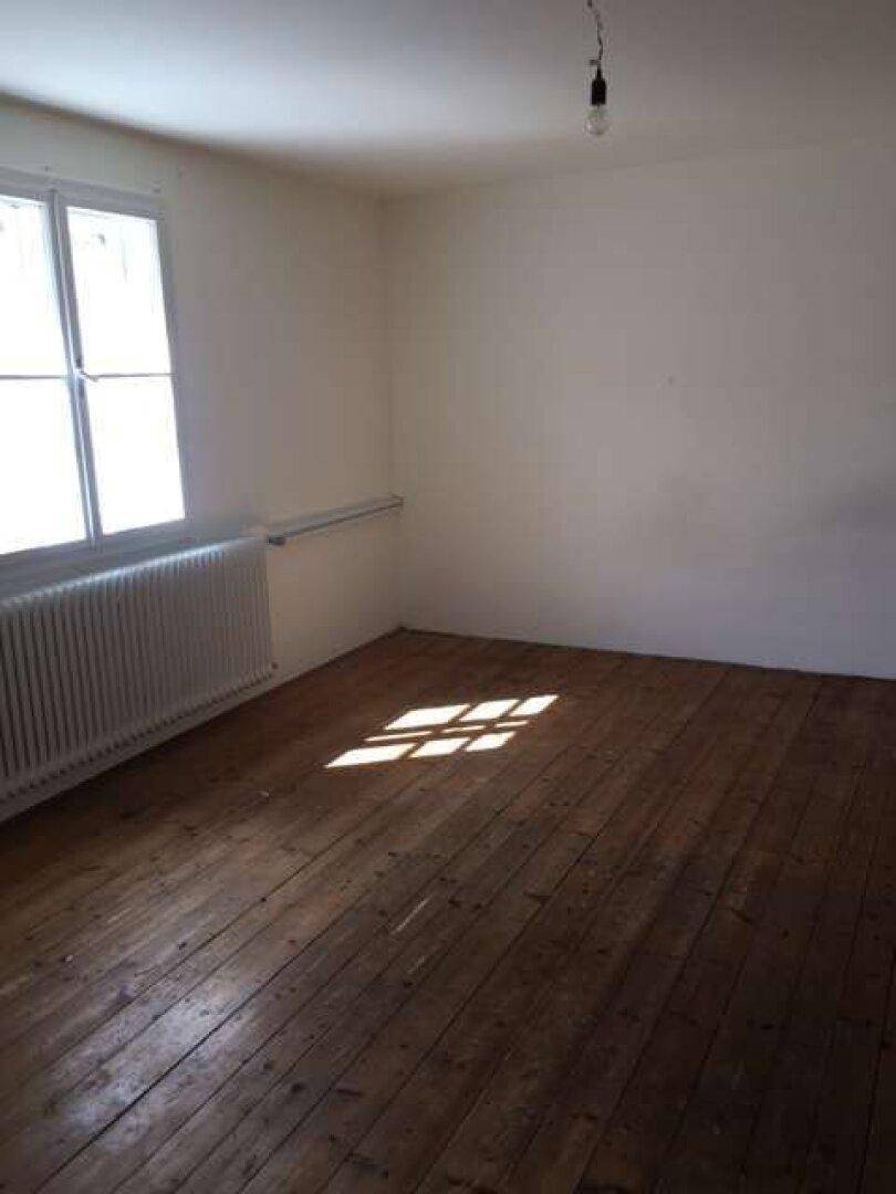 Geräumiges Zimmer mit Holzdielenboden, großem Fenster und viel Tageslicht.