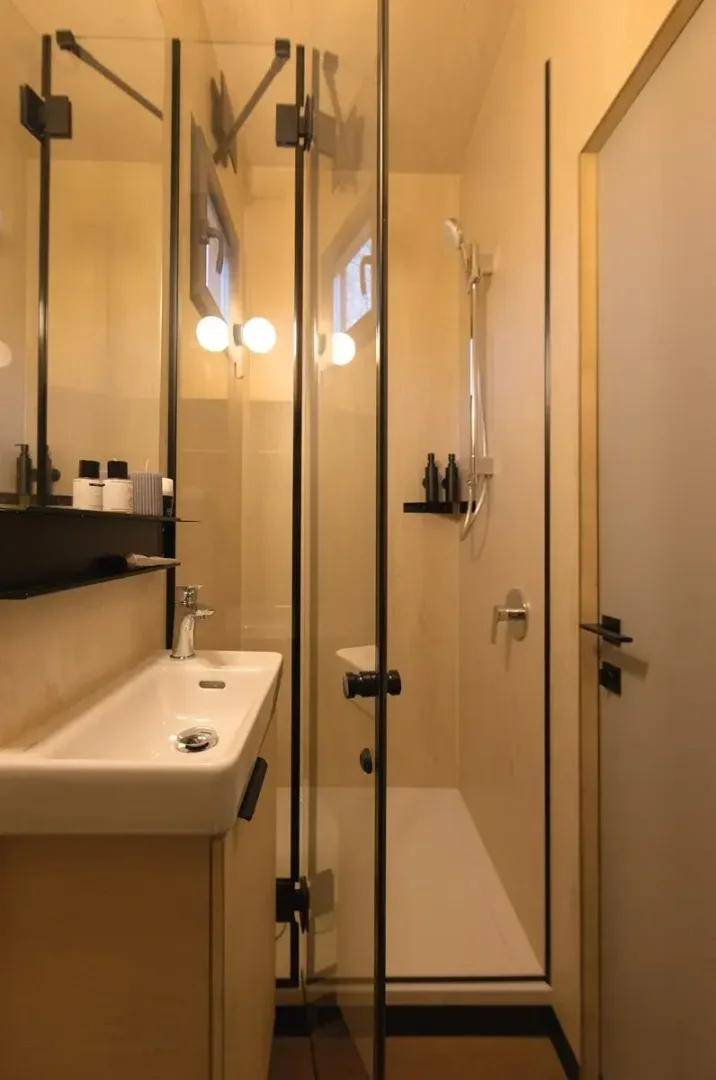 Modernes Badezimmer mit begehbarer Dusche, elegantem Waschbecken und minimalistischer Einrichtung.