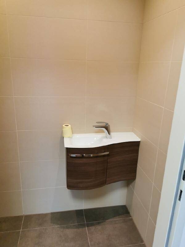 Kleines Gäste-WC mit modernem Waschbecken und dunklem Unterschrank.