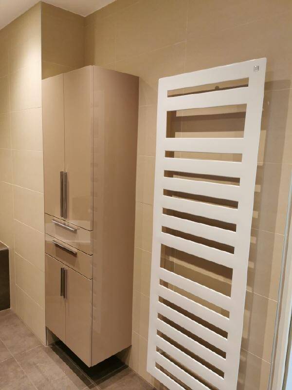 Badezimmer mit hohem Schrank für zusätzlichen Stauraum und beheiztem Handtuchhalter.