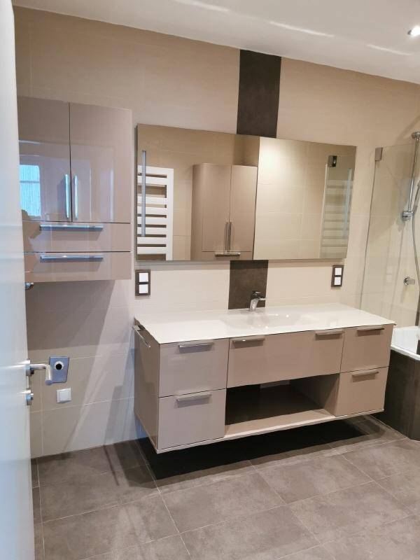 Modernes Badezimmer mit Doppelwaschbecken, Spiegelschrank und eleganten Fliesen.