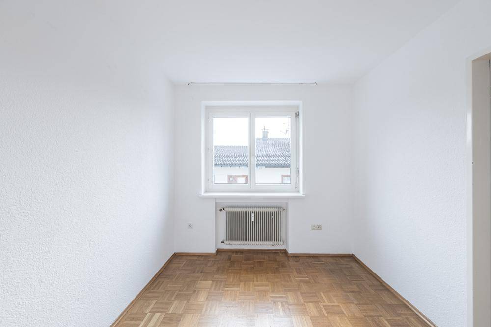 Kleiner, heller Raum mit Parkettboden und Fenster, geeignet als Schlaf- oder Arbeitszimmer.