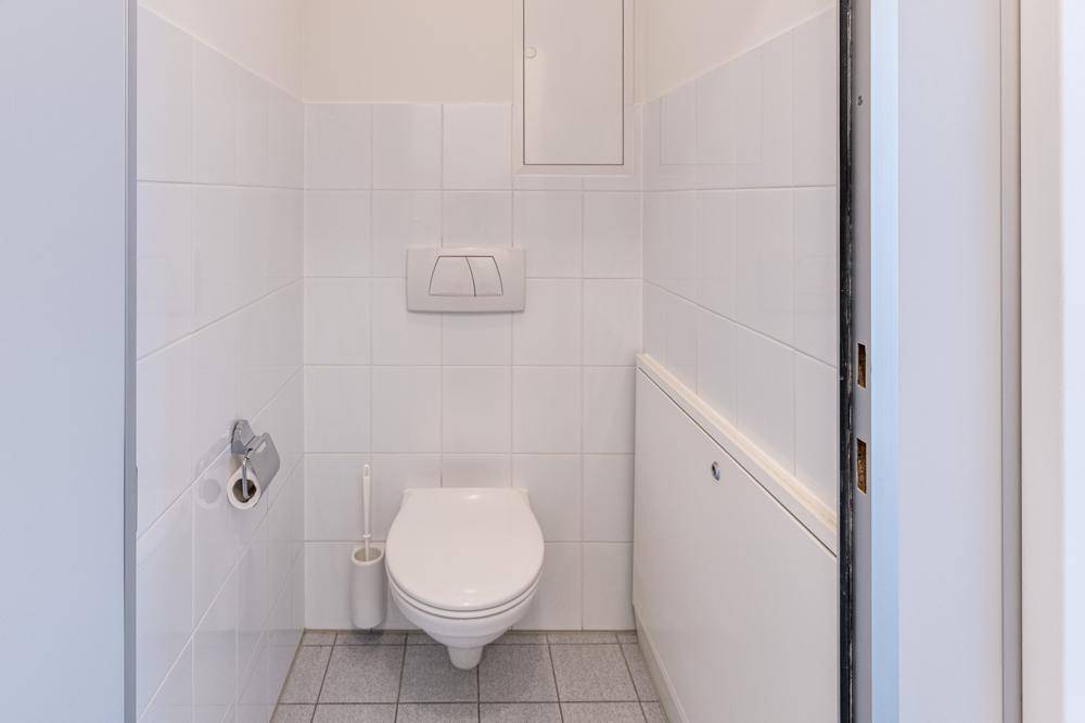 Saubere Gästetoilette mit Wand-WC und Fliesenboden, in gutem und gepflegtem Zustand.