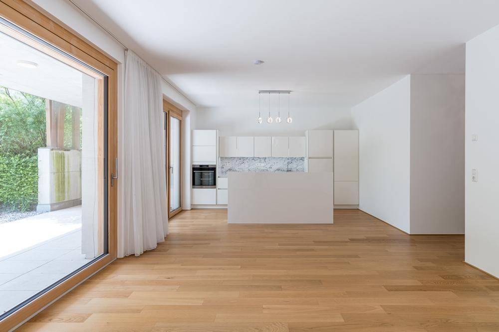 Geräumiger, offener Wohnbereich mit moderner Küche und Zugang zur Terrasse.