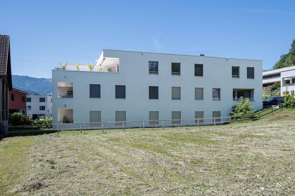 Modernes Mehrfamilienhaus mit klarer Architektur und großzügigen Terrassenbereichen.