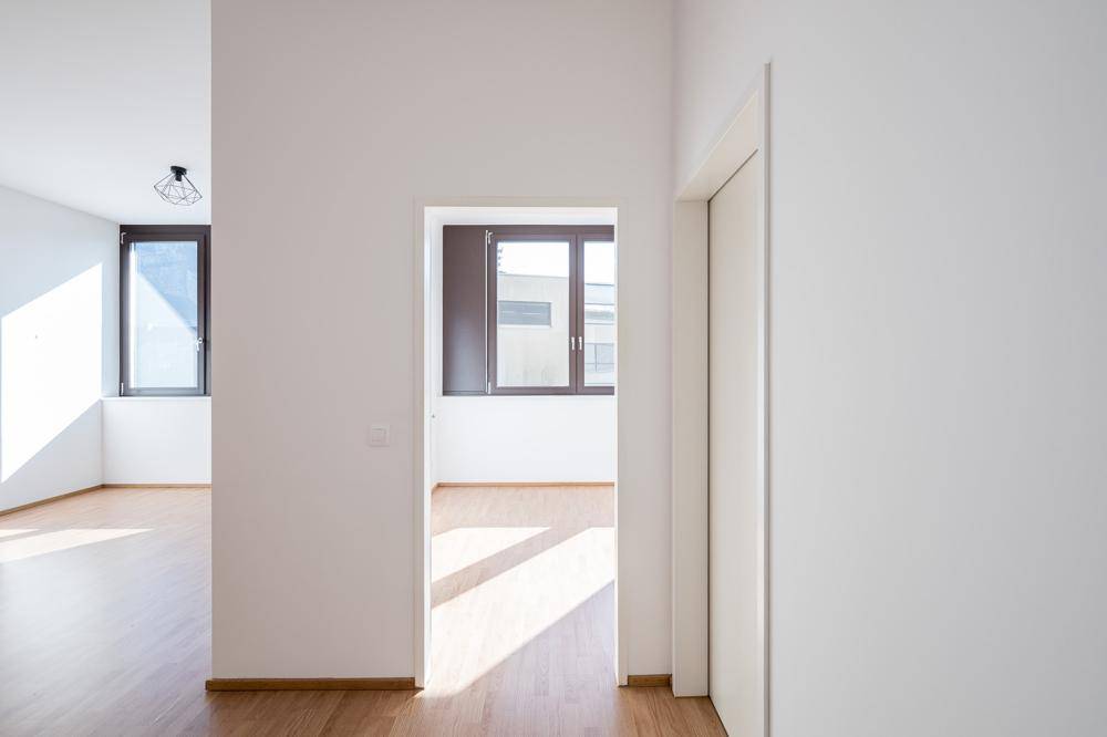 Heller Flur mit Laminatboden und Durchgängen zu weiteren lichtdurchfluteten Räumen.