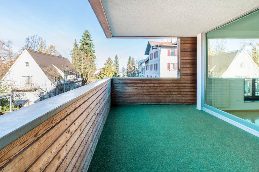 Geräumiger Balkon mit Holzwänden und Blick auf die Umgebung.