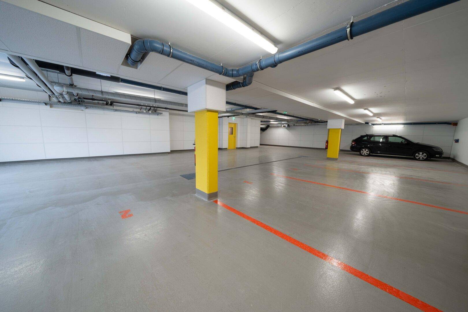 Geräumige Tiefgarage mit ausreichend Stellplätzen und guter Beleuchtung.