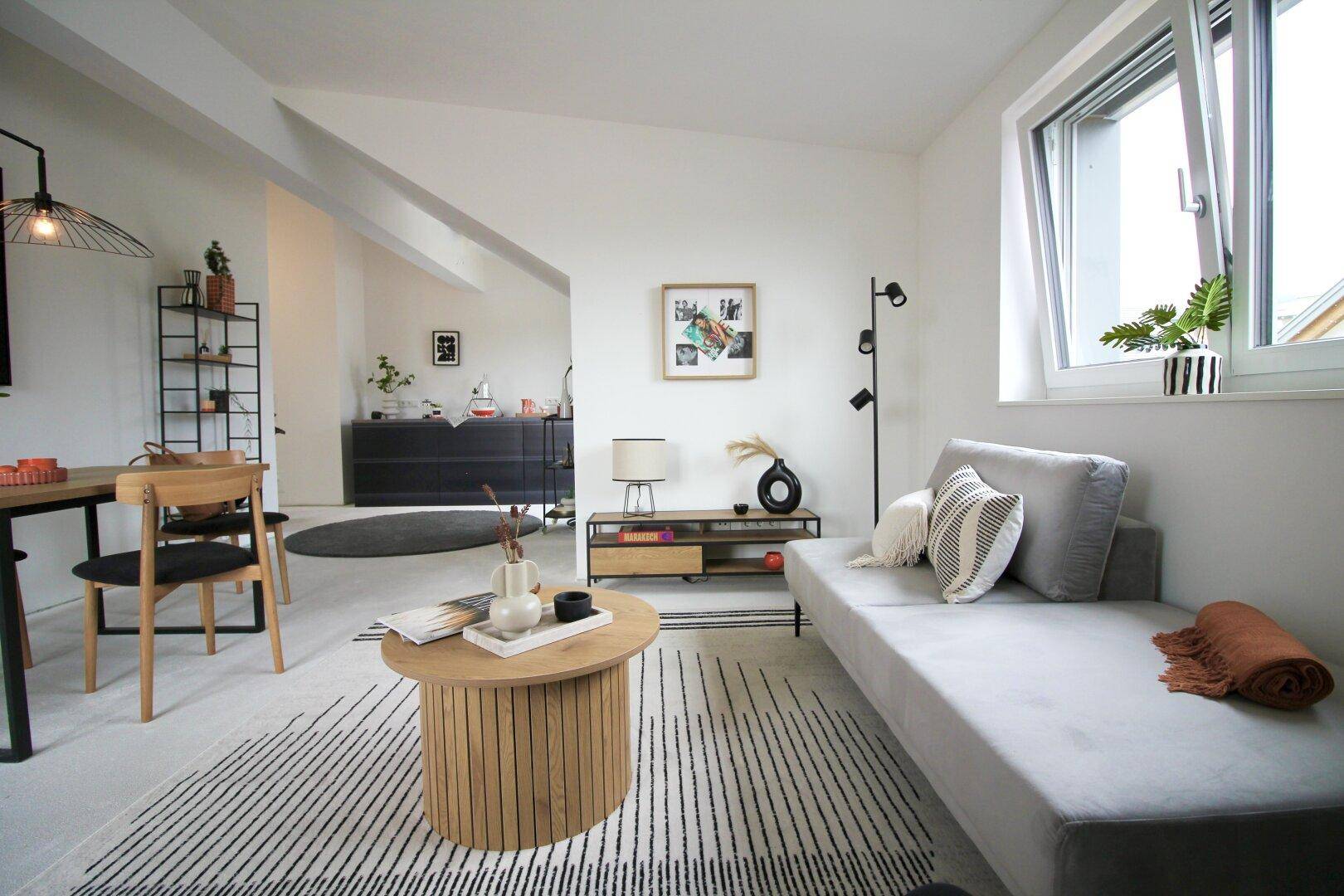 Gemütlicher Wohnbereich mit bequemen Sofas, Holztisch und stilvoller Dekoration in hellen Tönen.