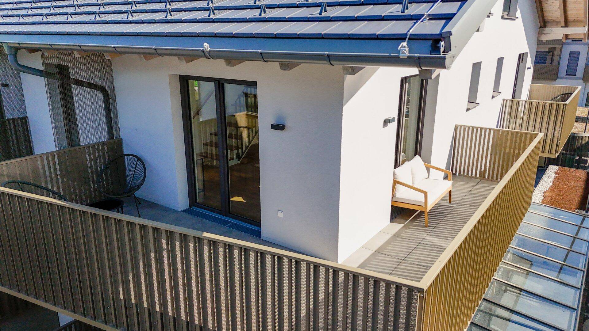 Geräumiger Balkon mit Holzgeländer und Sitzgelegenheiten, ideal zum Entspannen im Freien.