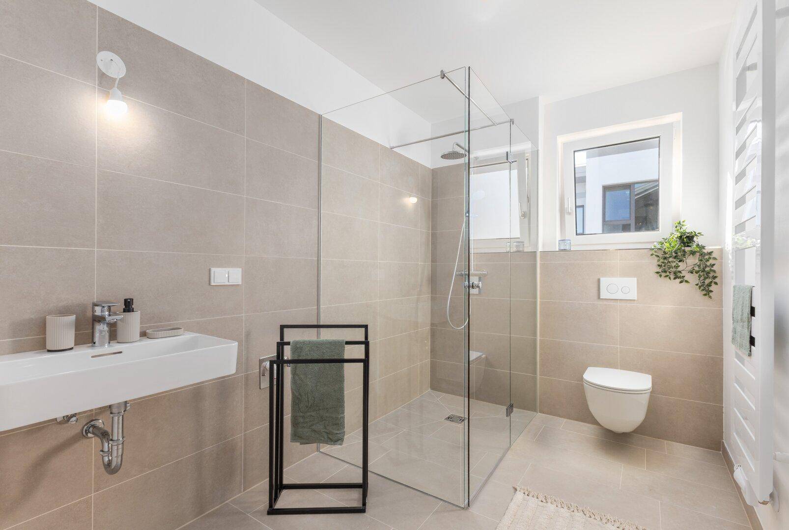Modernes Badezimmer mit ebenerdiger Dusche, Fenster und hellen Fliesen.