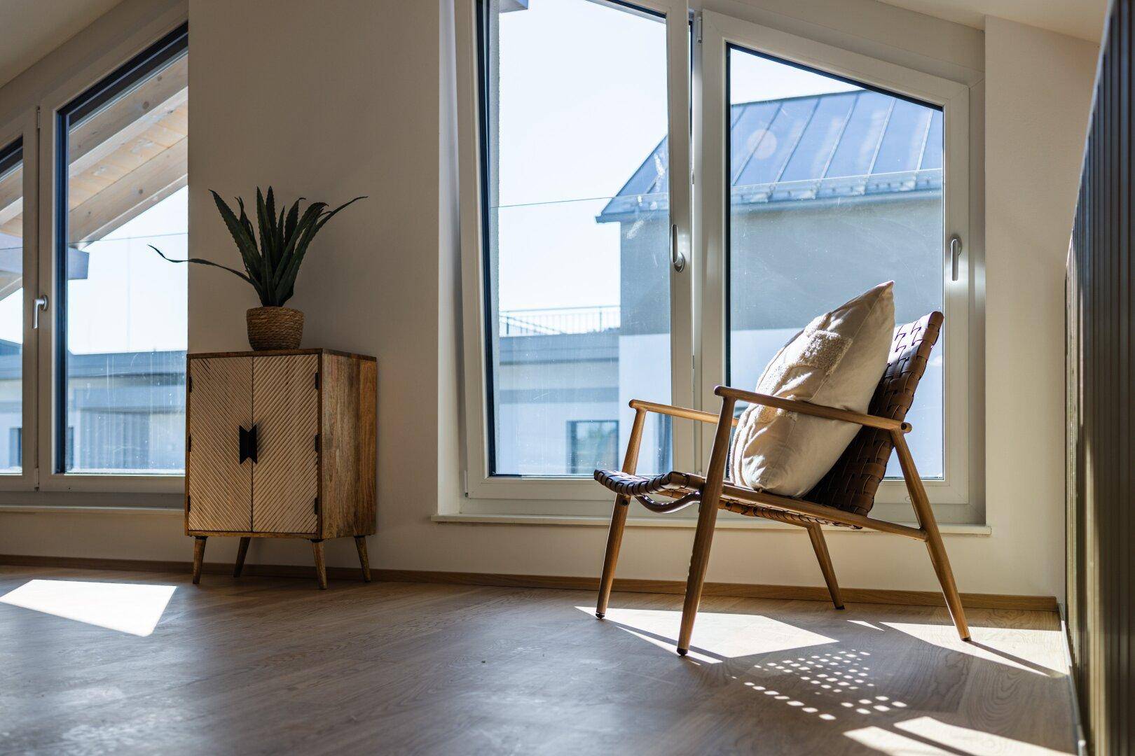 Gemütlicher Sessel am Fenster auf der Galerie mit viel Tageslicht.