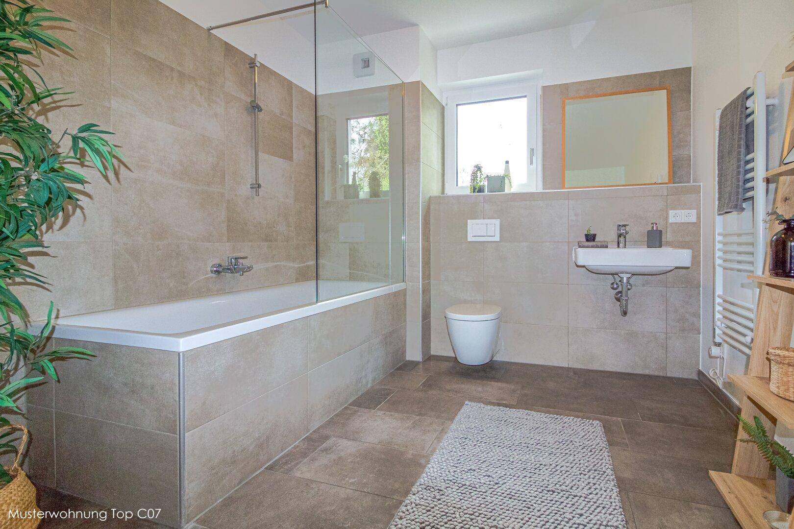 Modernes Badezimmer mit beigefarbenen Fliesen, Badewanne mit Duschbereich und Fenster.
