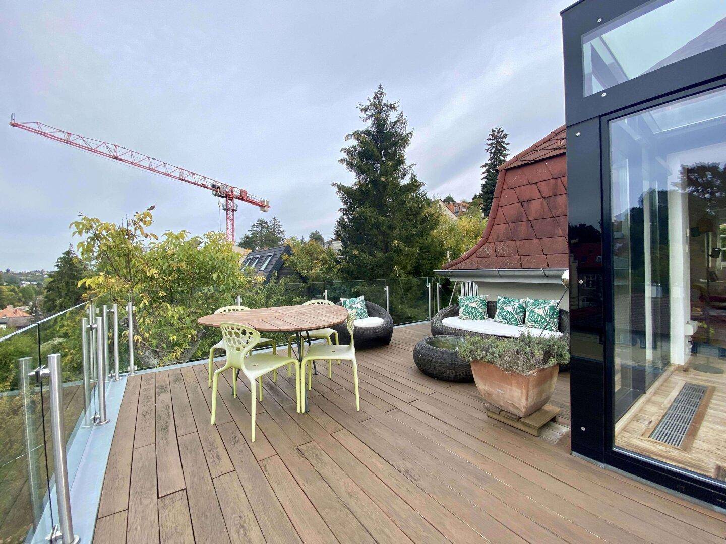 Weitläufige Terrasse mit Sitzgelegenheiten und Panoramablick über die Baumwipfel.